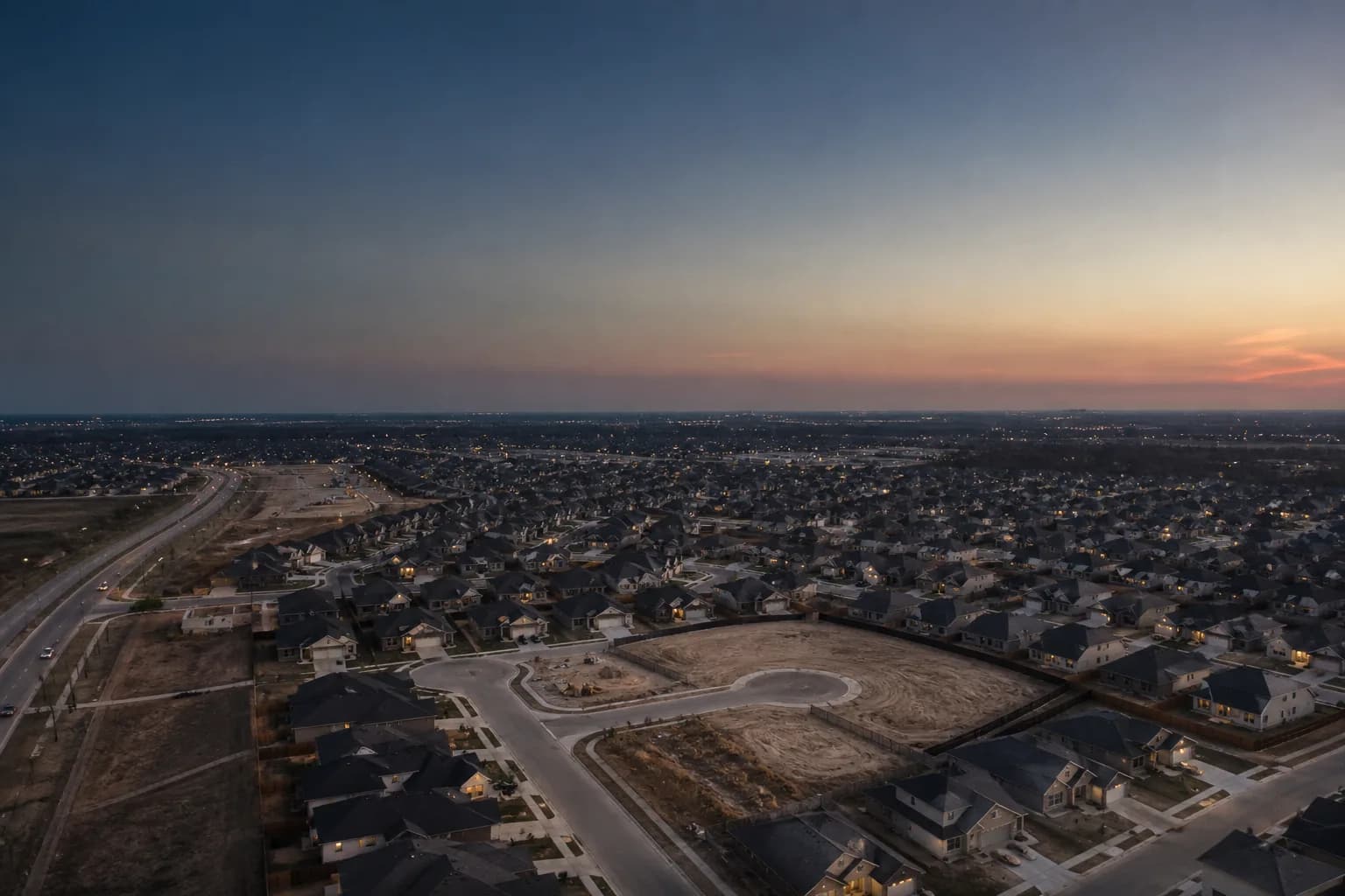 Aerial view of a Texas suburban housing development with unsold homes, illustrating falling home prices in 2026